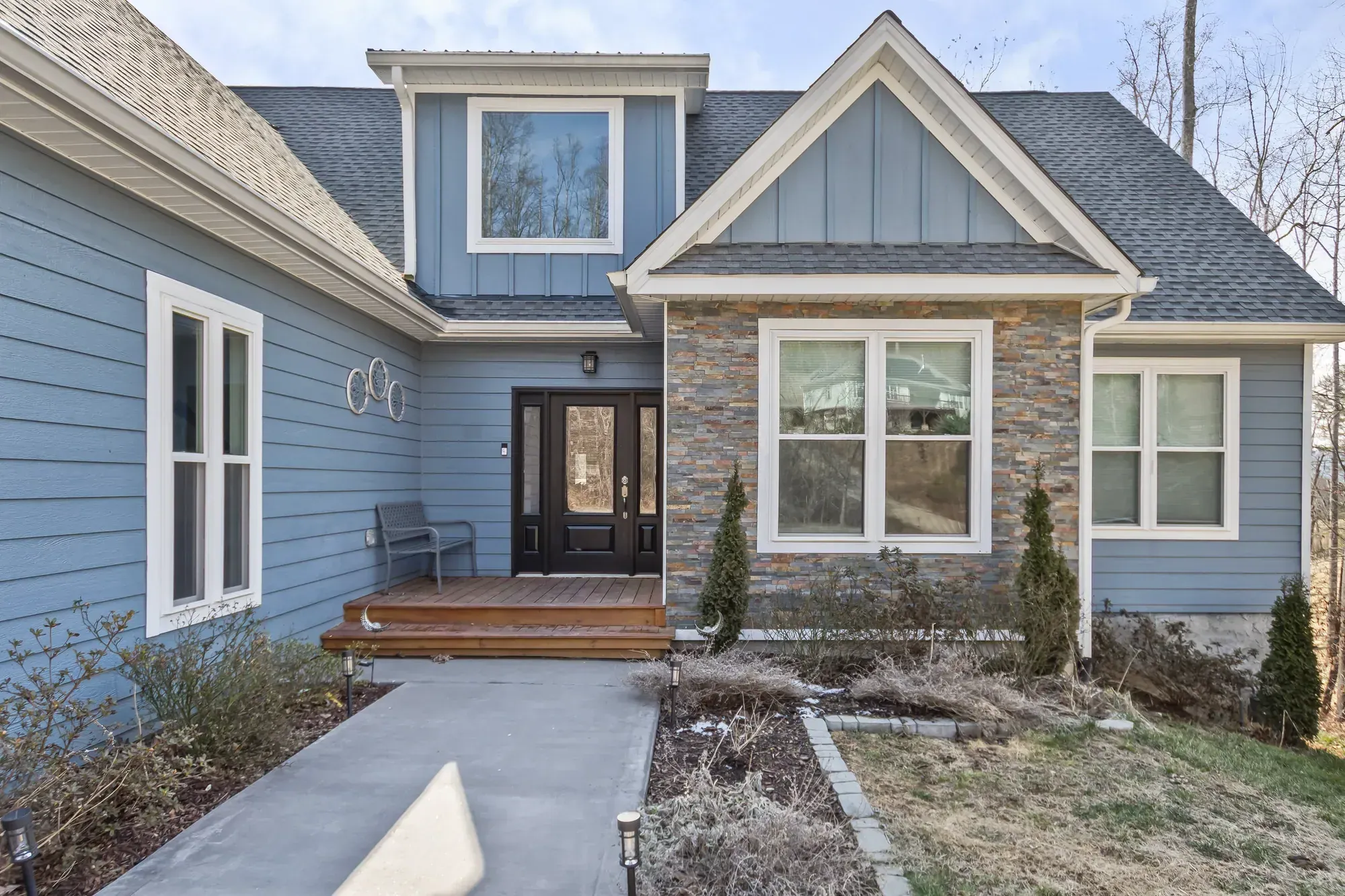 Wood front stoop, stacked-stone wall and board-and-batten gable on a Weaverville, NC custom home, built by Buckingham Builders